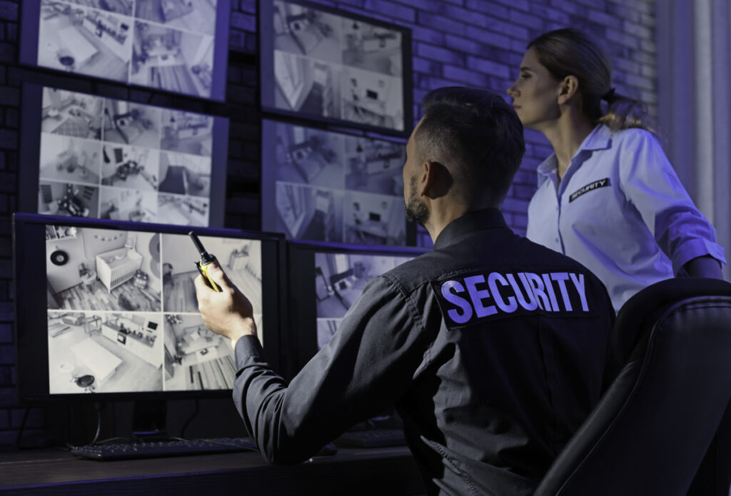 Security guards monitoring modern CCTV cameras indoors