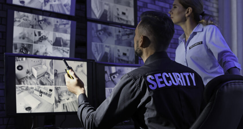 Security guards monitoring modern CCTV cameras indoors
