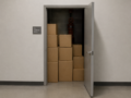 Open door to a fire sprinkler room with stacked cardboard boxes and red piping visible on the back wall.